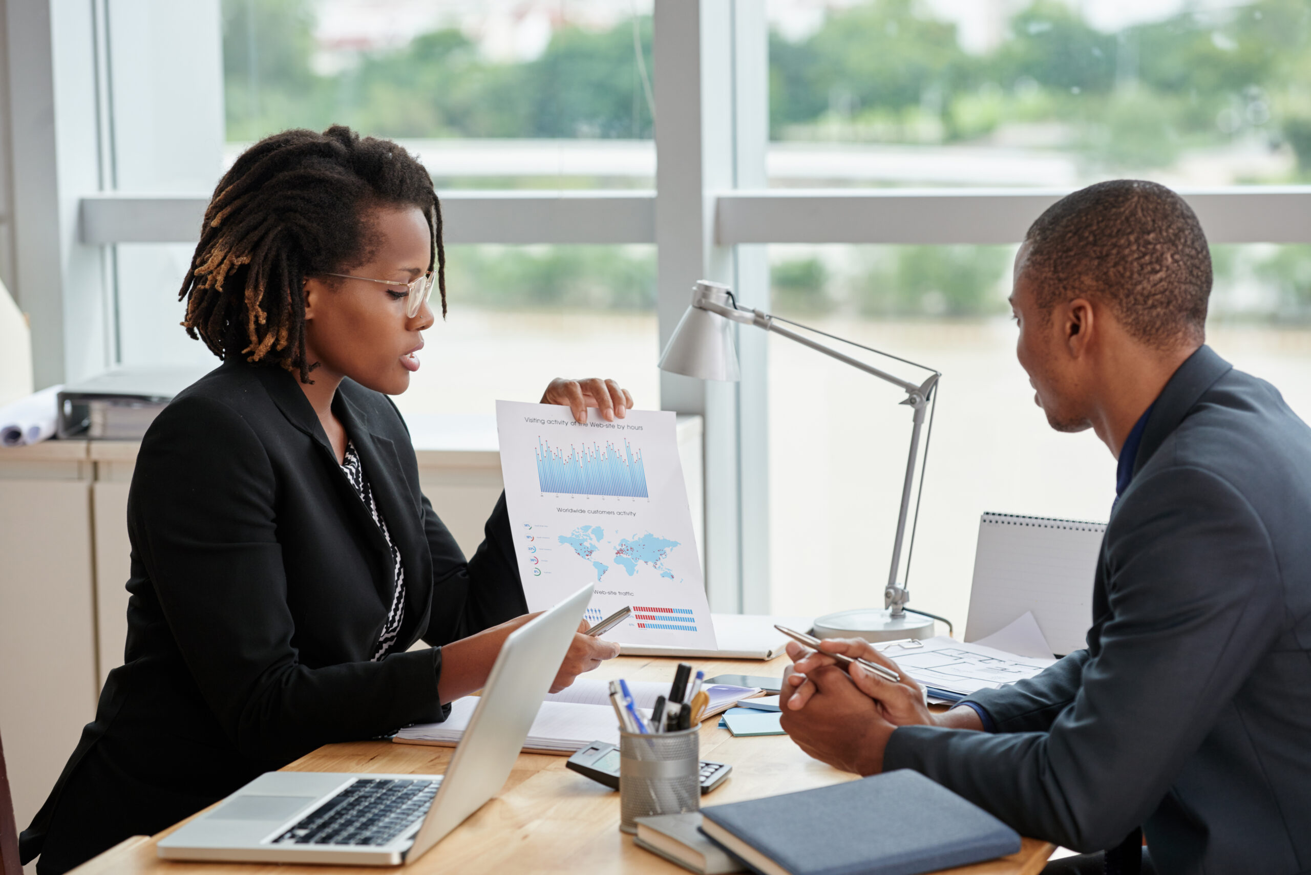 Business woman showing diagram and explaining information to entrepreneur